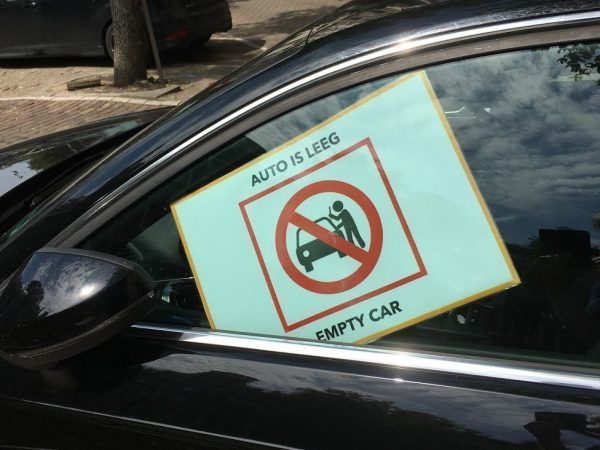 Plaatje van verkeersbord in geparkeerde auto met de tekst: Auto is leeg - Empty car.